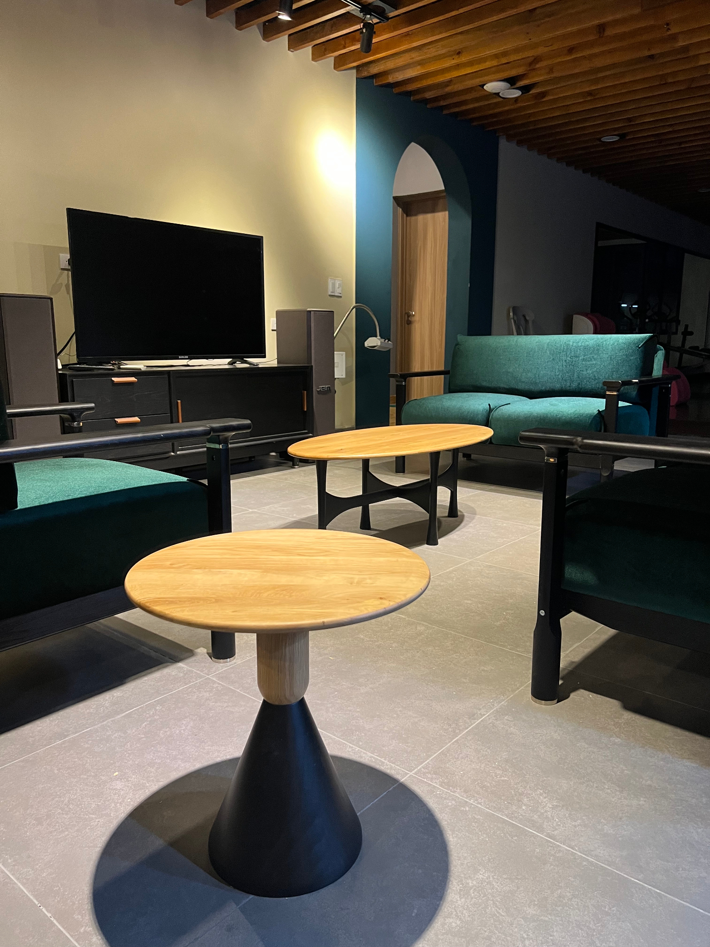 OEM showroom lifestyle — round side tables with dark wood media console